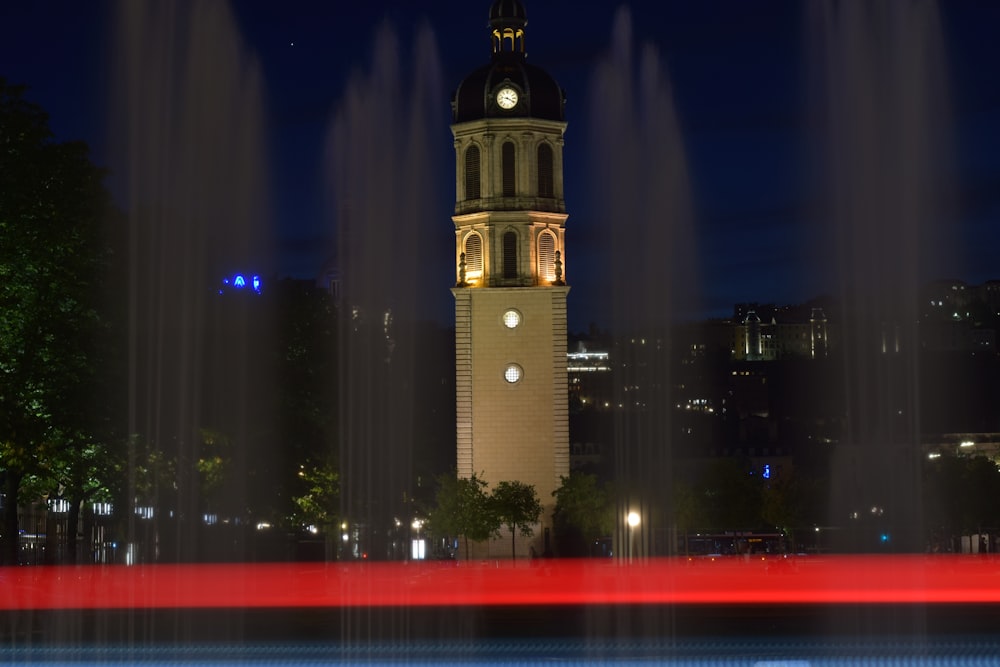 a large clock tower towering over a city at night