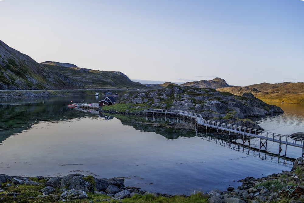 a dock on a lake surrounded by mountains