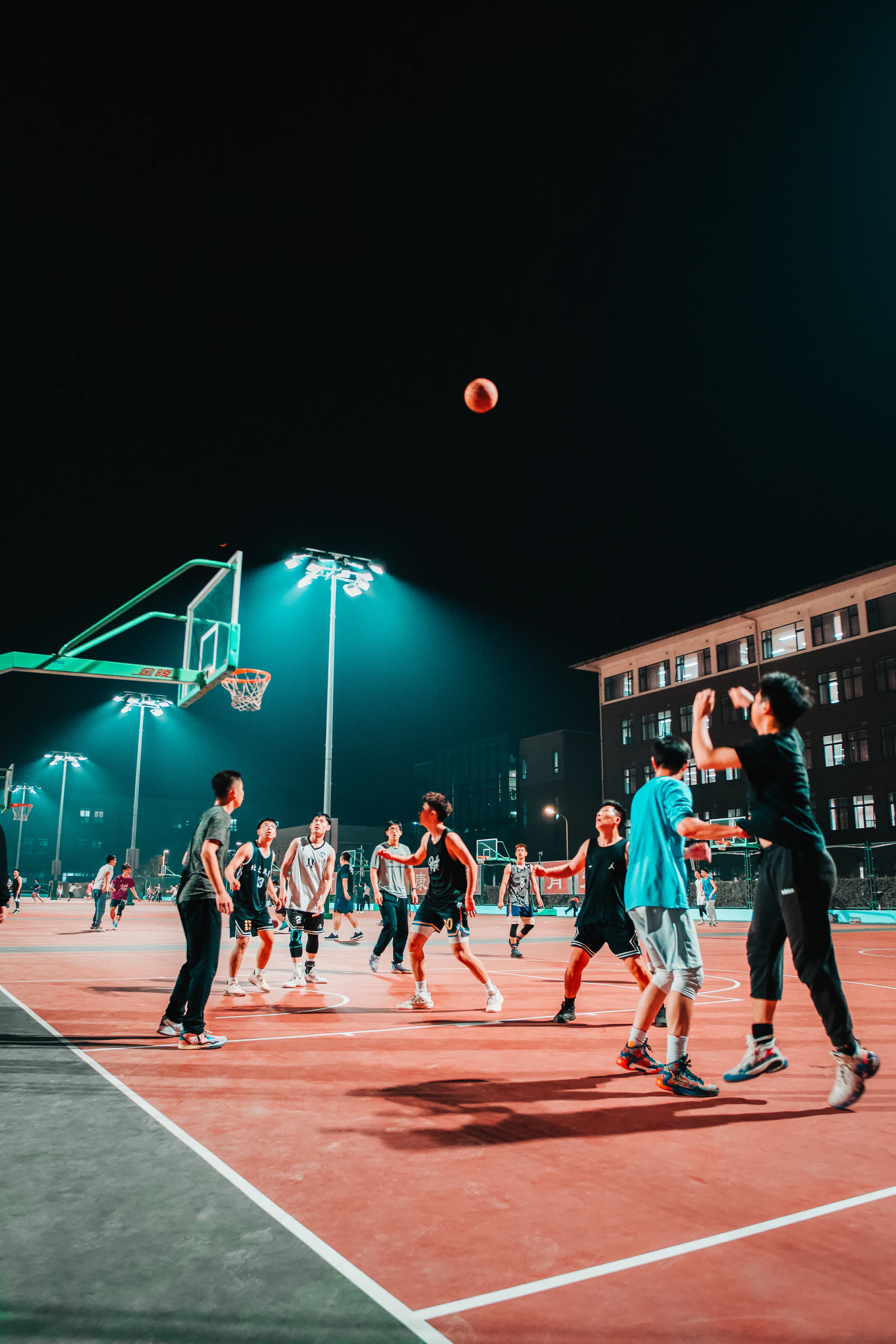夜の体育館でバスケットボールをする学生