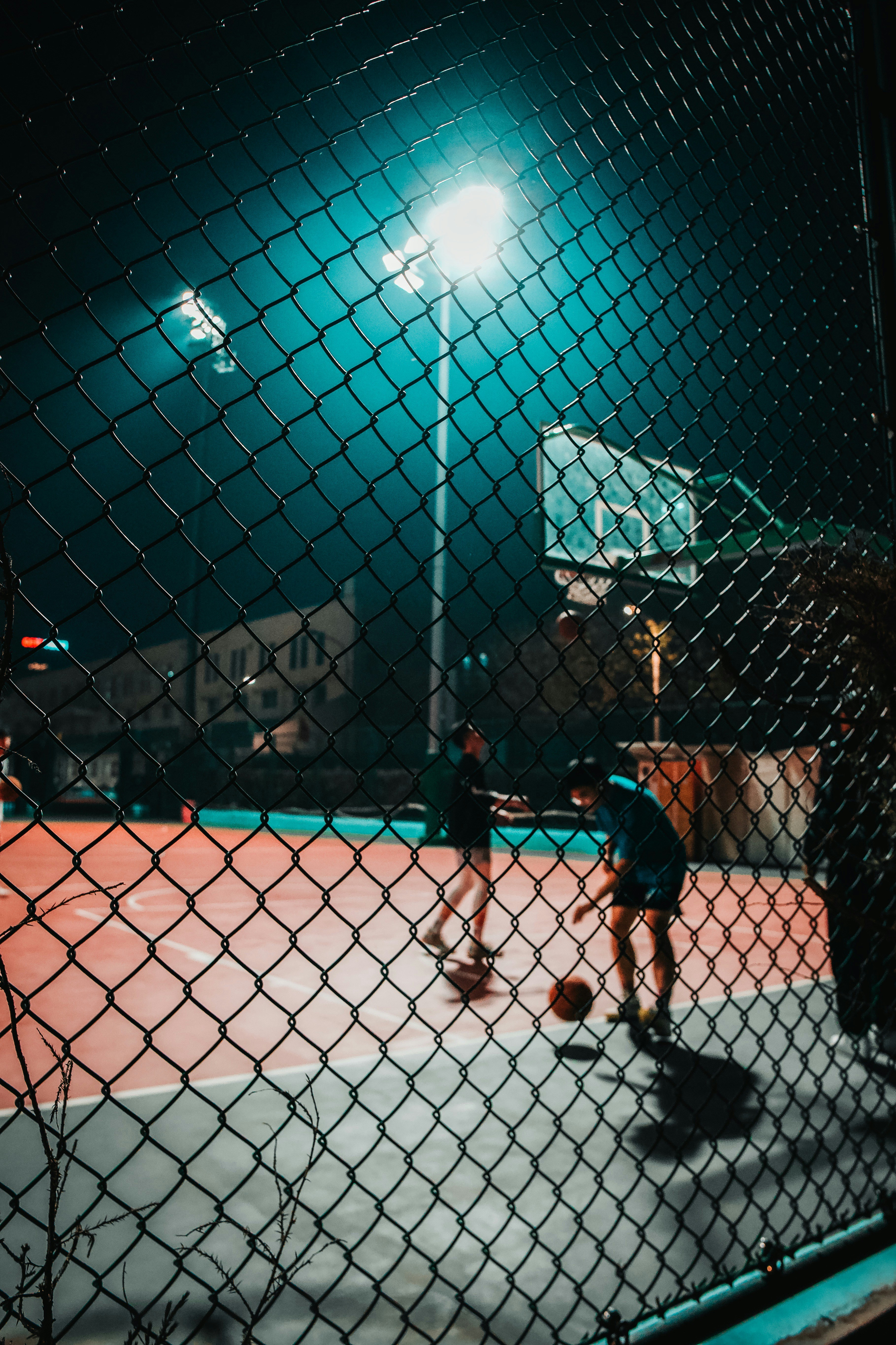 a couple of people playing basketball on a court