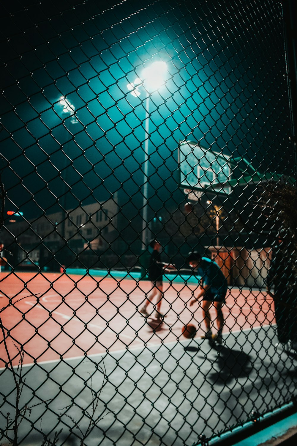 a couple of people playing basketball on a court