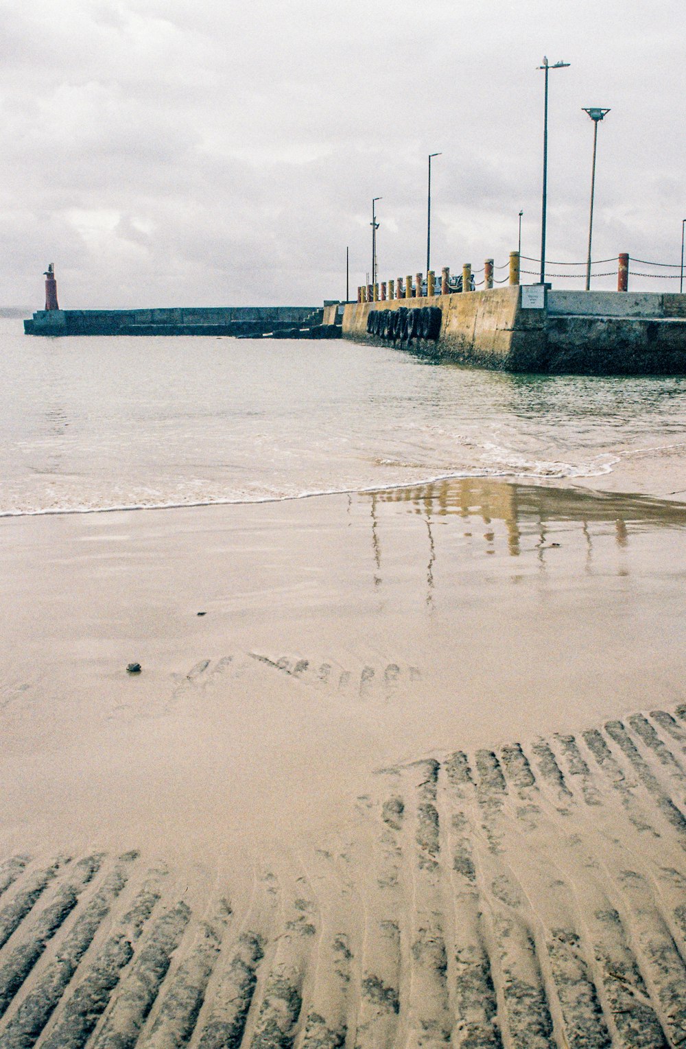 a sandy beach with a light house in the distance