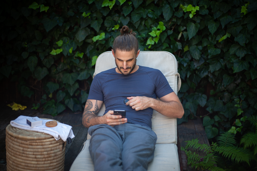 a man sitting in a chair looking at a cell phone