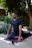 a man sitting on a yoga mat in the middle of a garden