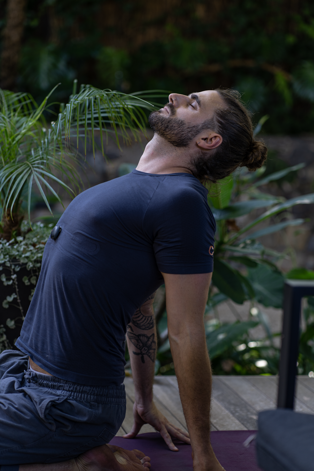 a man sitting on a yoga mat in the middle of a forest