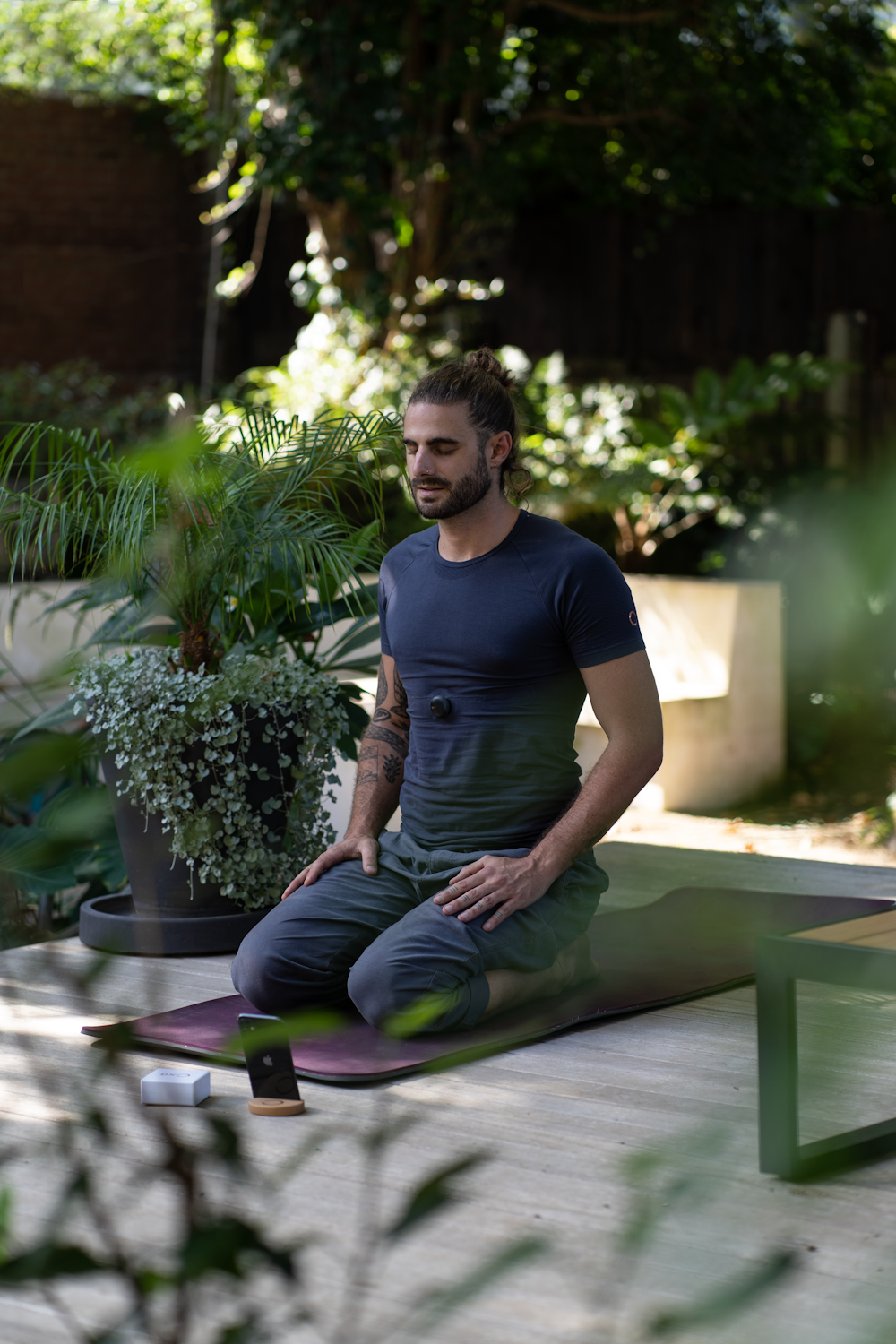 a man sitting on a skateboard in a garden