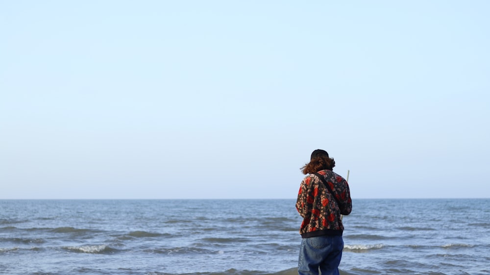 a man standing on a beach next to the ocean