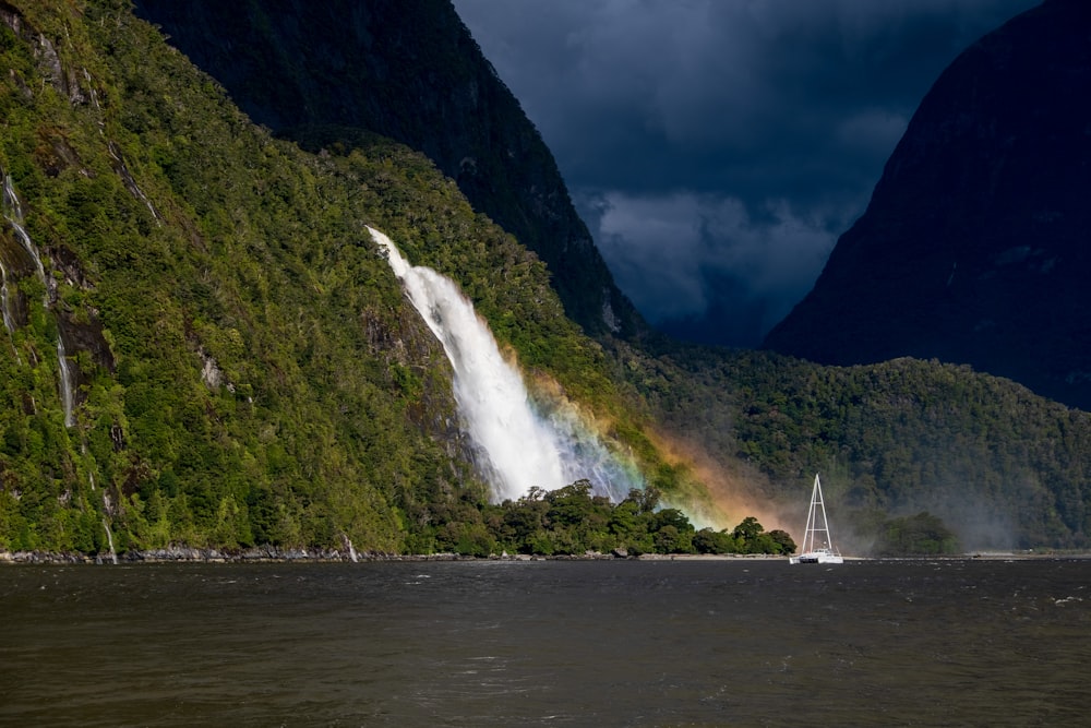 a boat is in the water near a waterfall