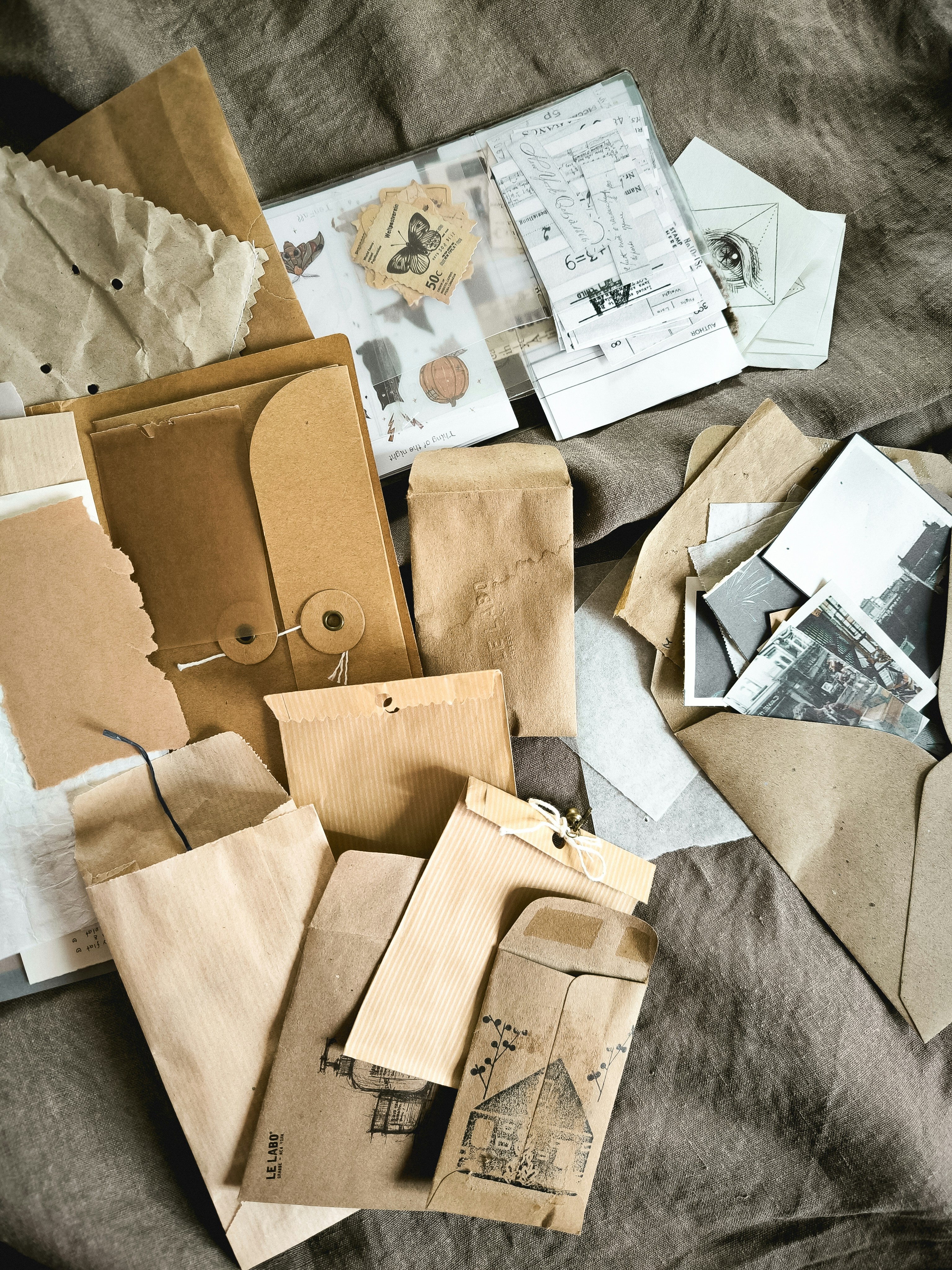 a pile of old envelopes sitting on top of a bed