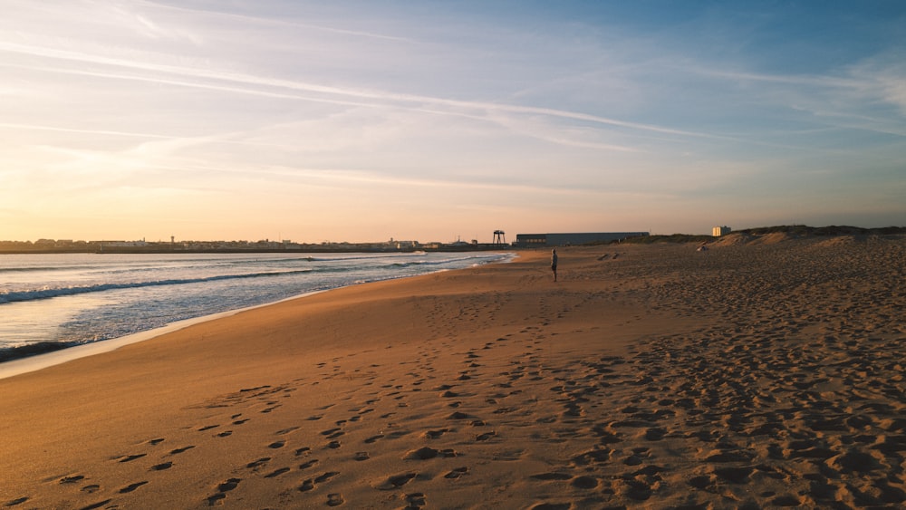 a person walking on a beach near the ocean