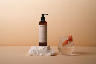 a bottle of shampoo next to a glass of water