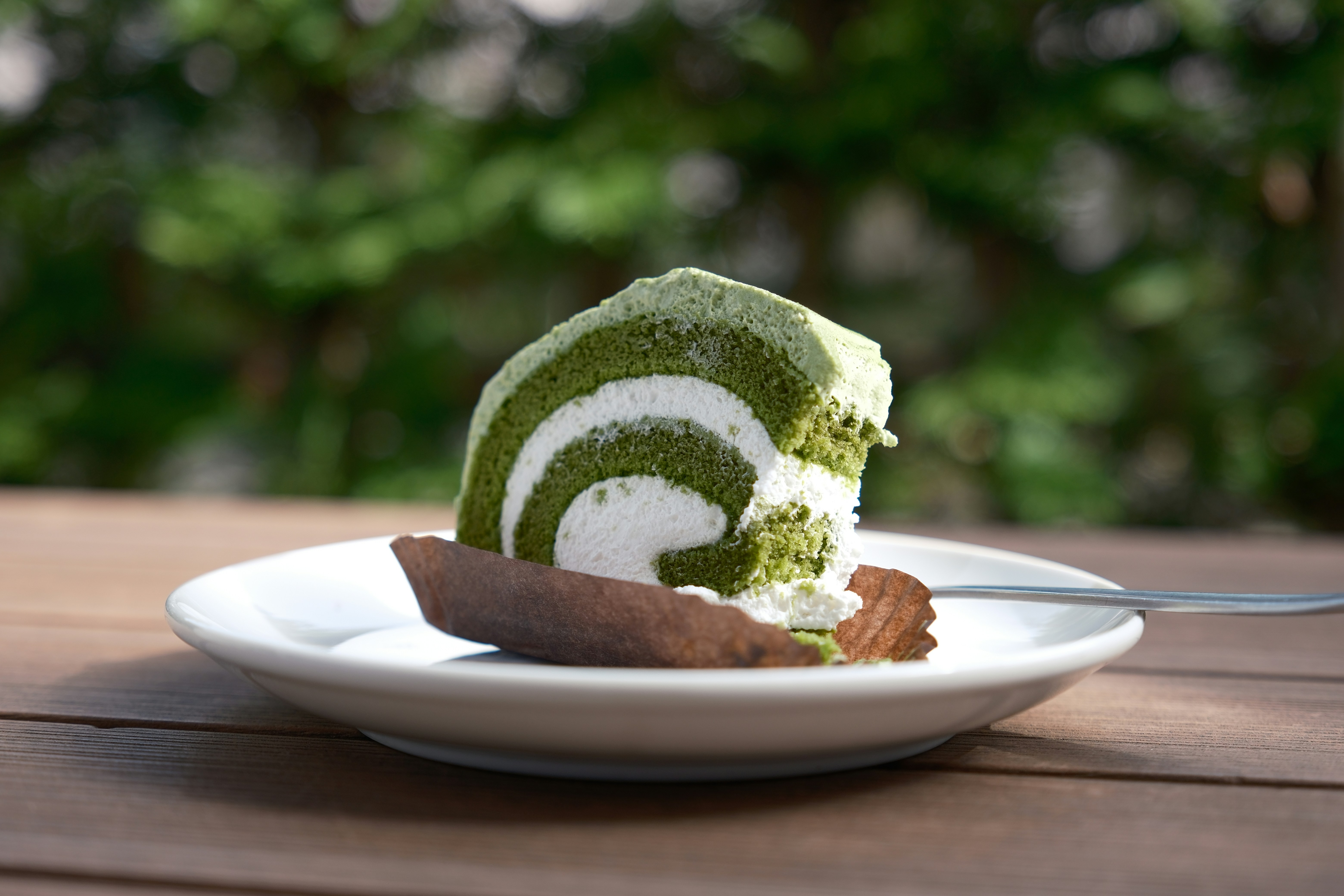 Slice of matcha roll cake with a fork