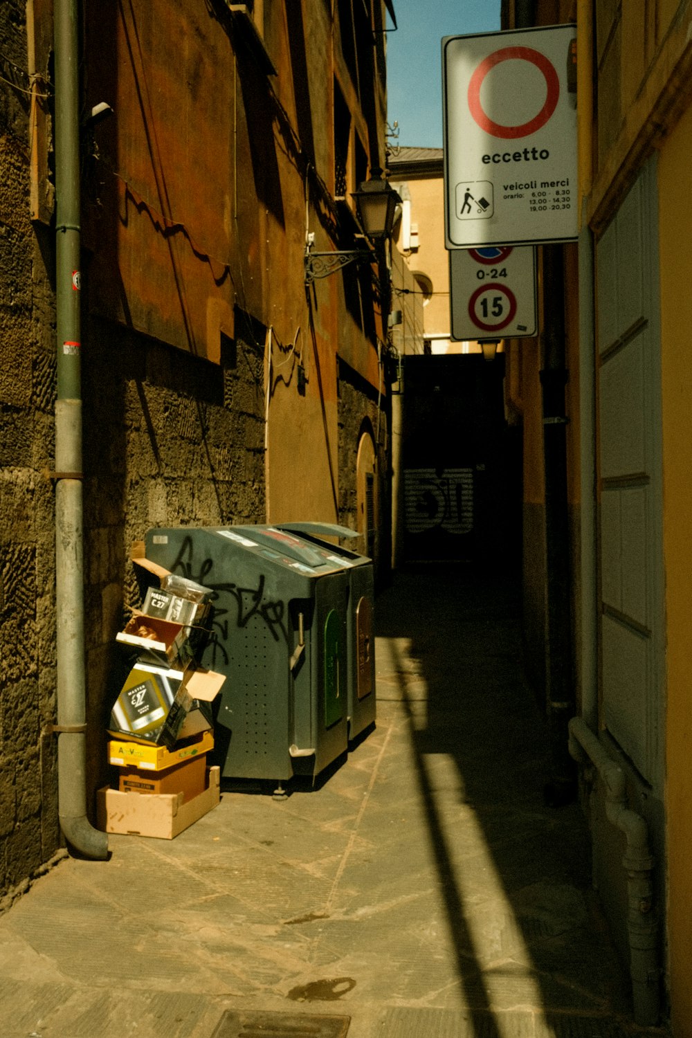 an alleyway with a box and a sign on it