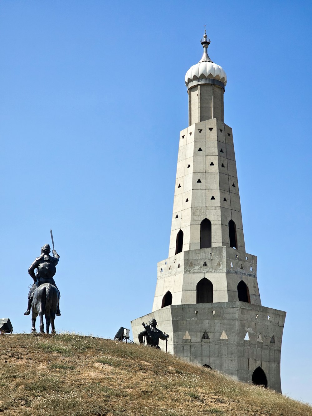 a statue of a man on a horse next to a tower