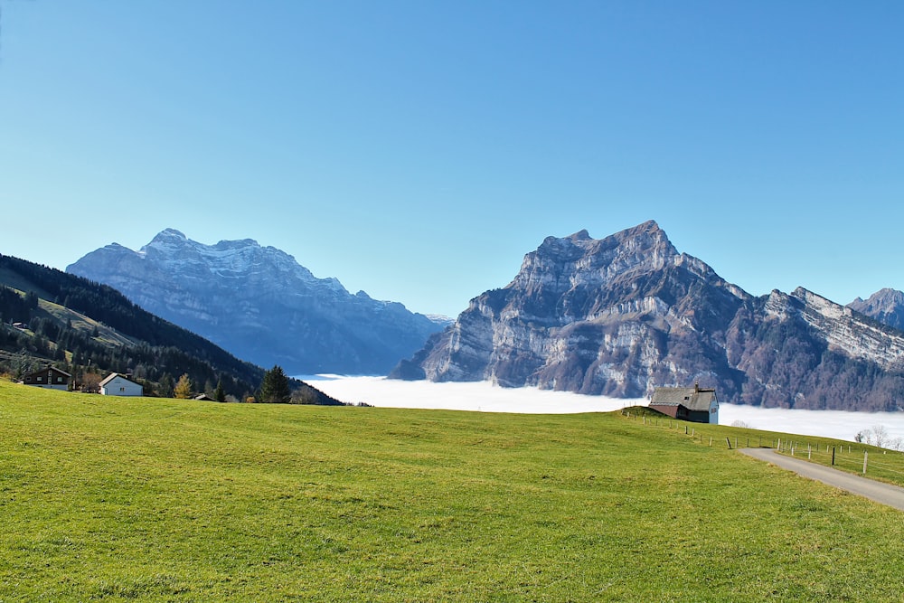 a scenic view of a mountain range with a house in the foreground