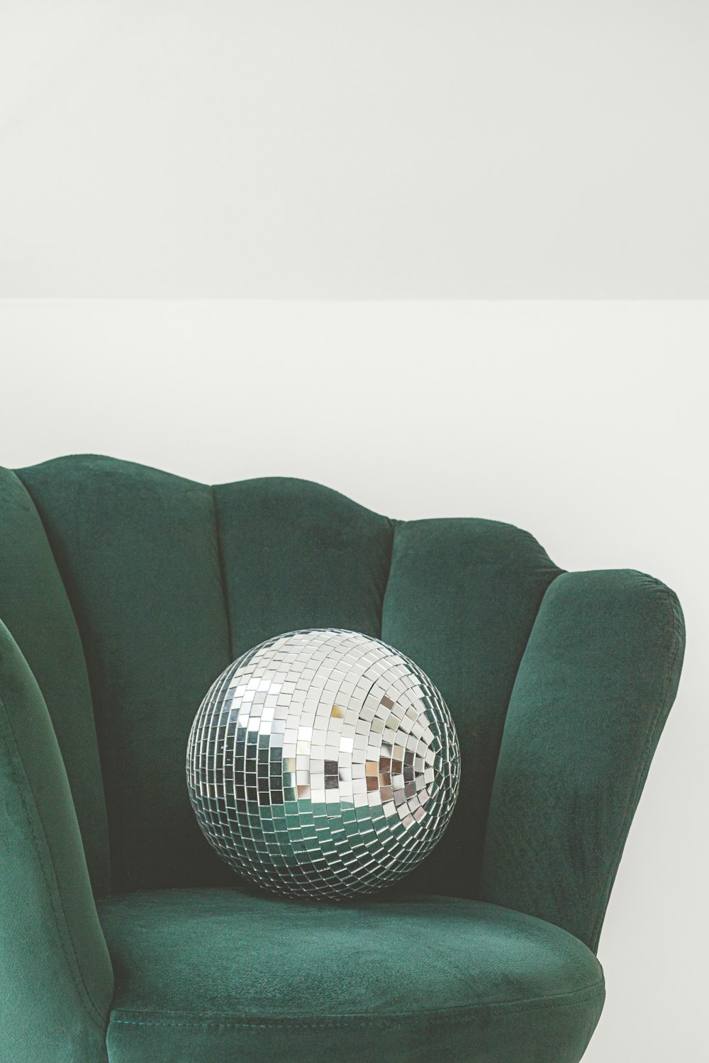 a green chair with a disco ball on top of it