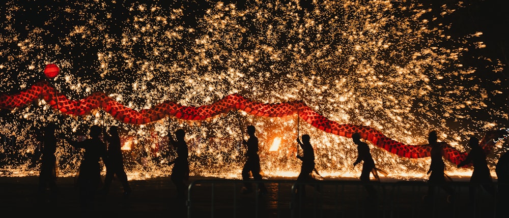 a group of people standing in front of a fire