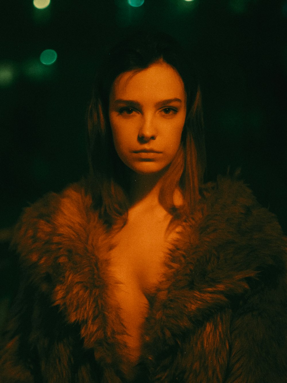 a woman wearing a fur coat in a dark room