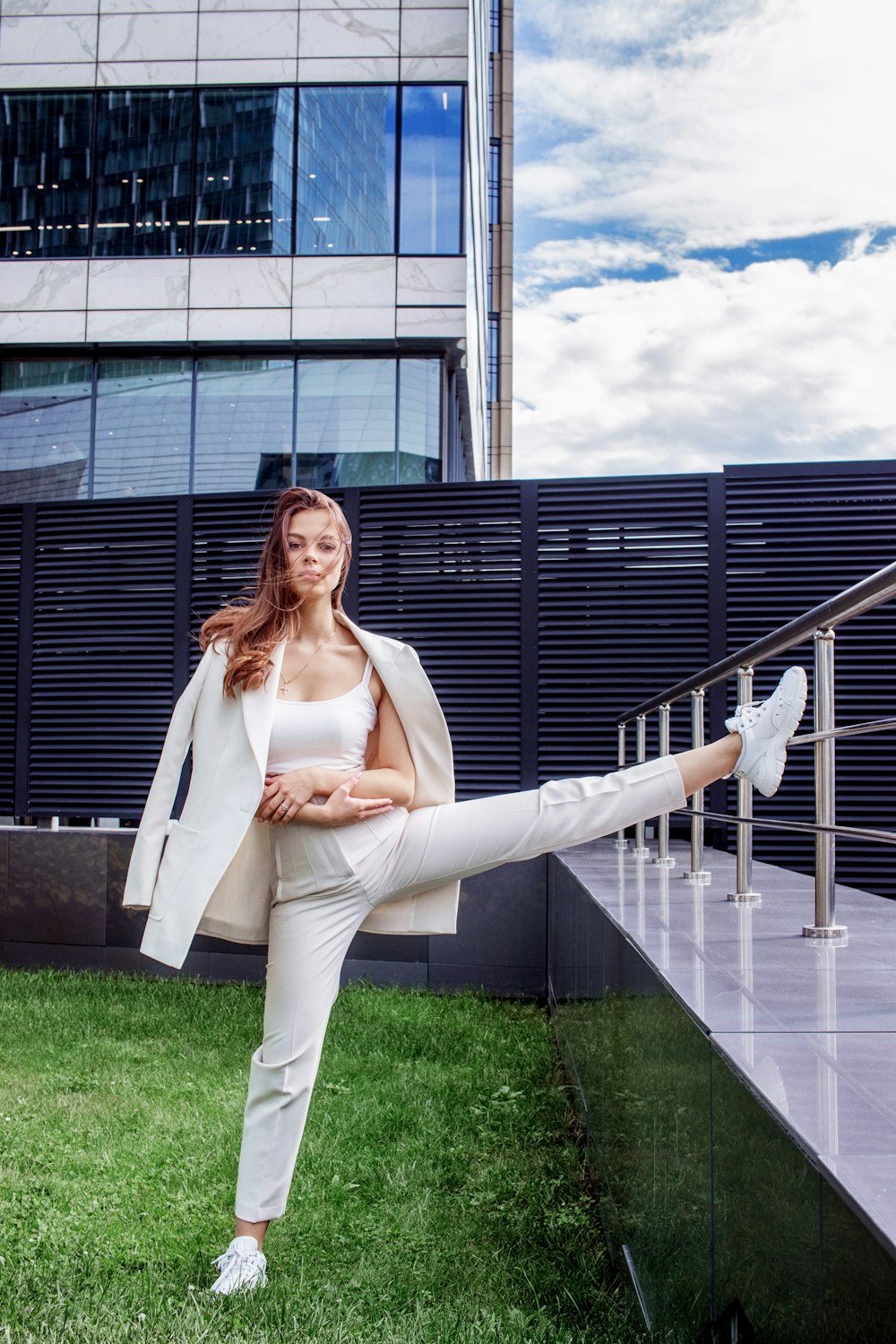 a woman in a white suit and white shoes posing for a picture