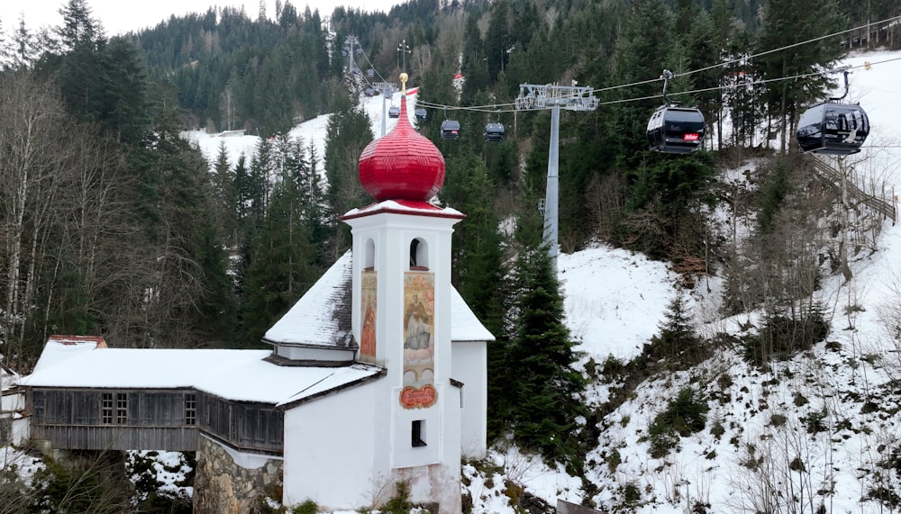 빨간 첨탑과 스키 리프트를 배경으로 한 흰색 교회