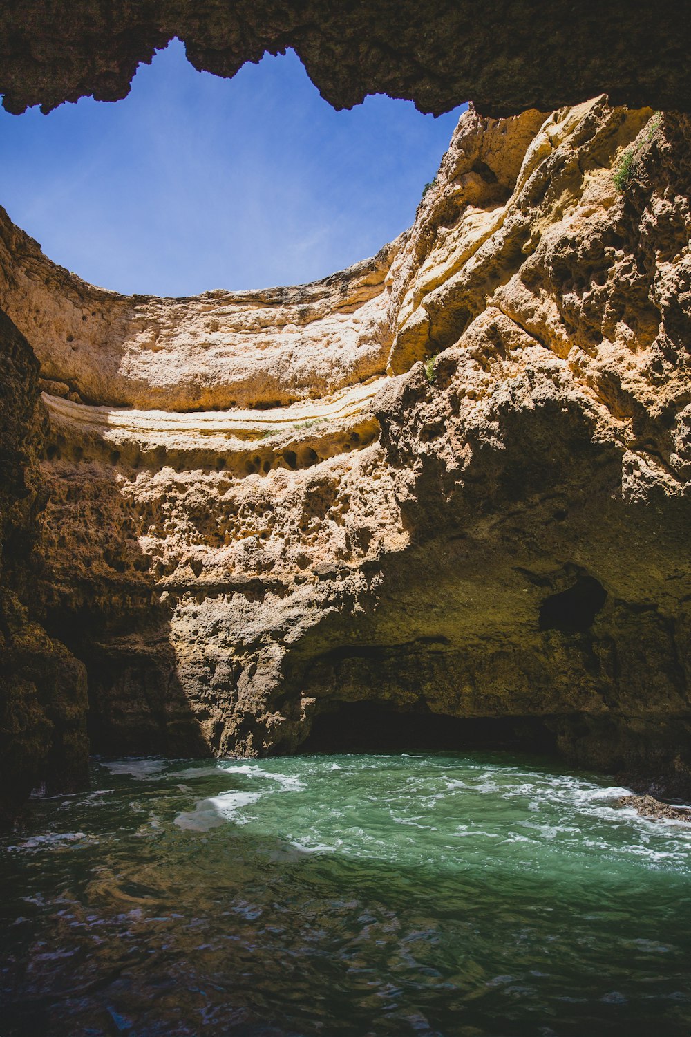 a view of a body of water from inside a cave