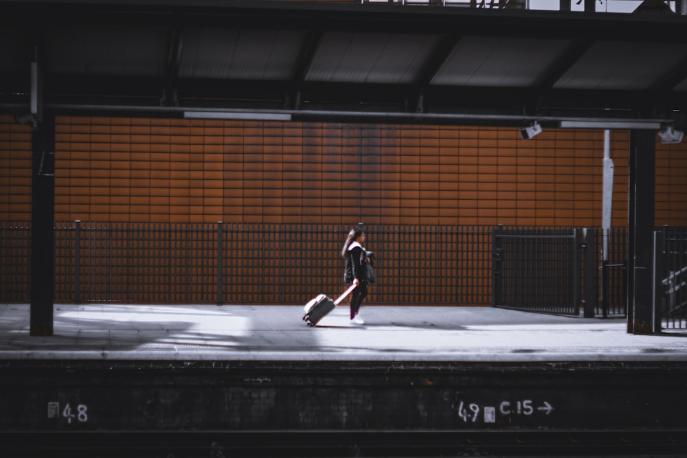 a person walking on a platform with a suitcase