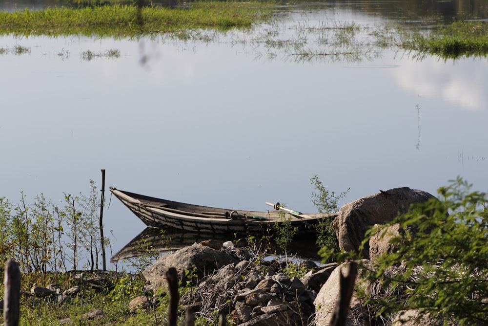 a boat sitting on the shore of a lake