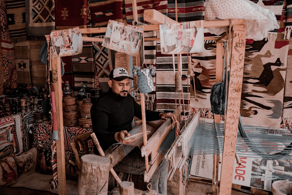a man working on a weaving machine in a shop