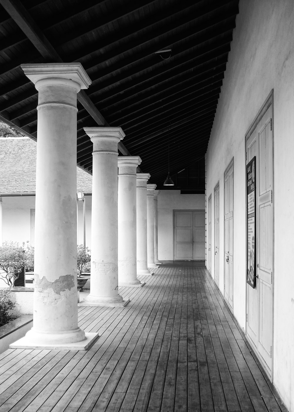 a black and white photo of a porch with columns