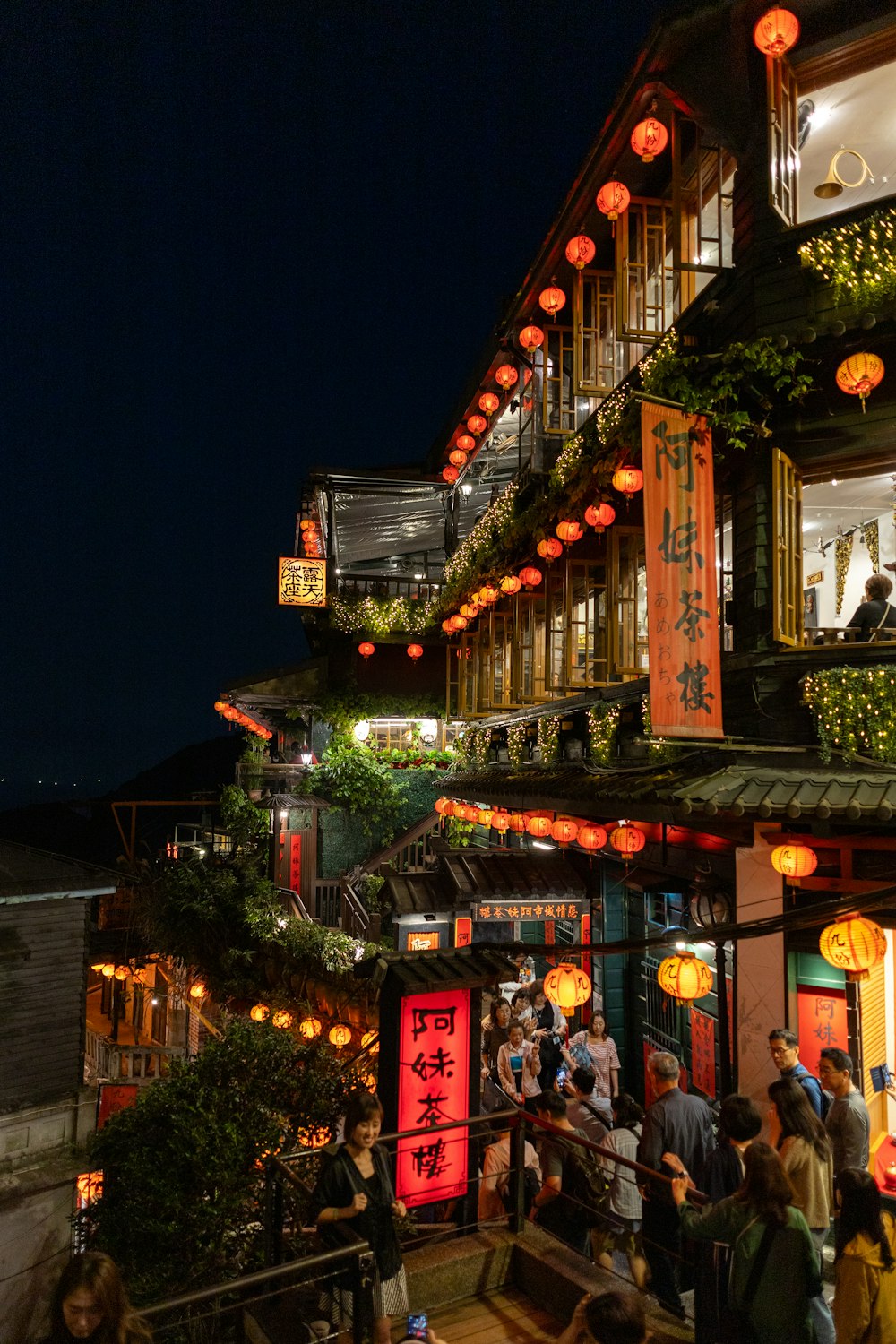 a group of people standing outside of a building at night