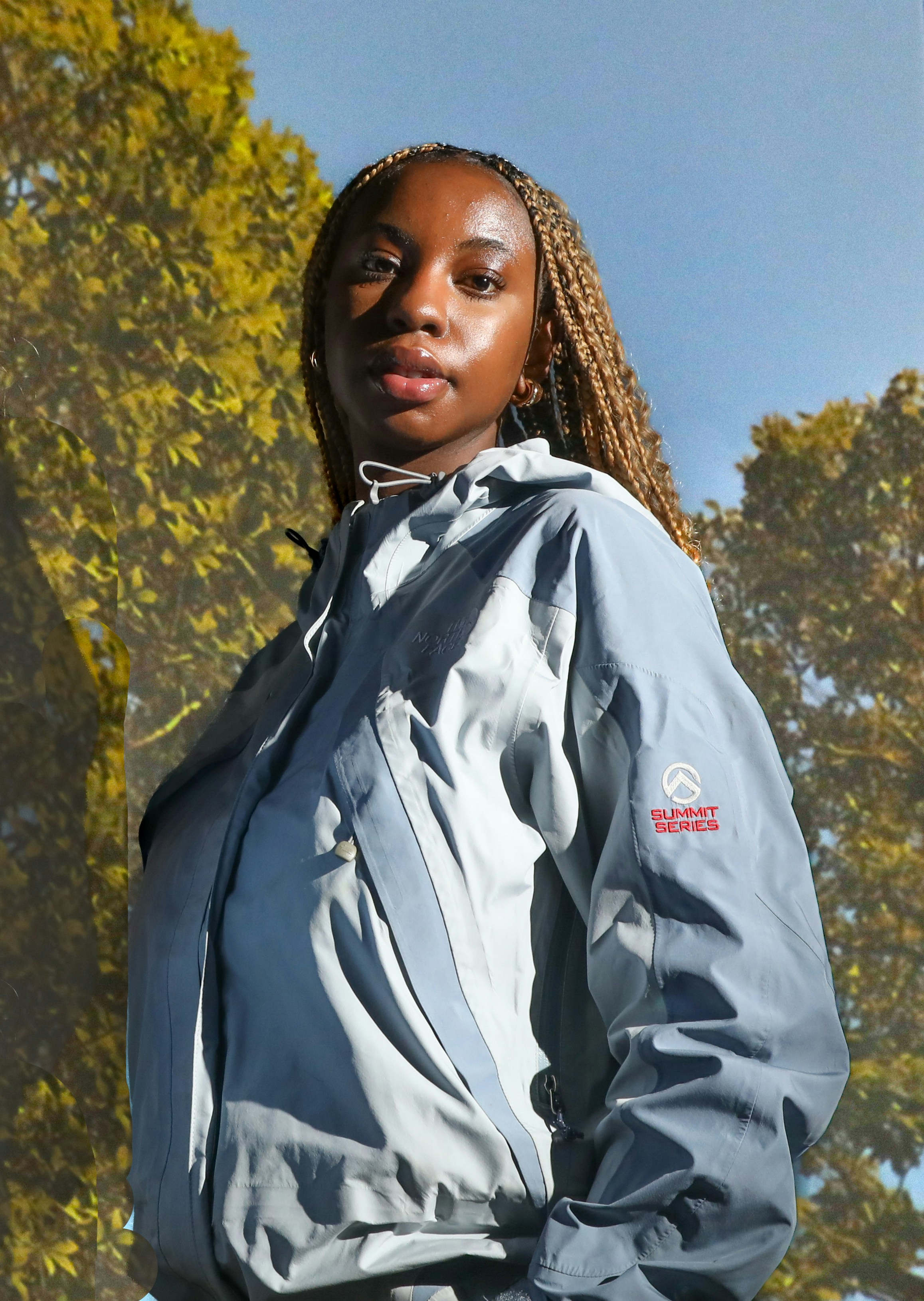 a woman standing in front of some trees