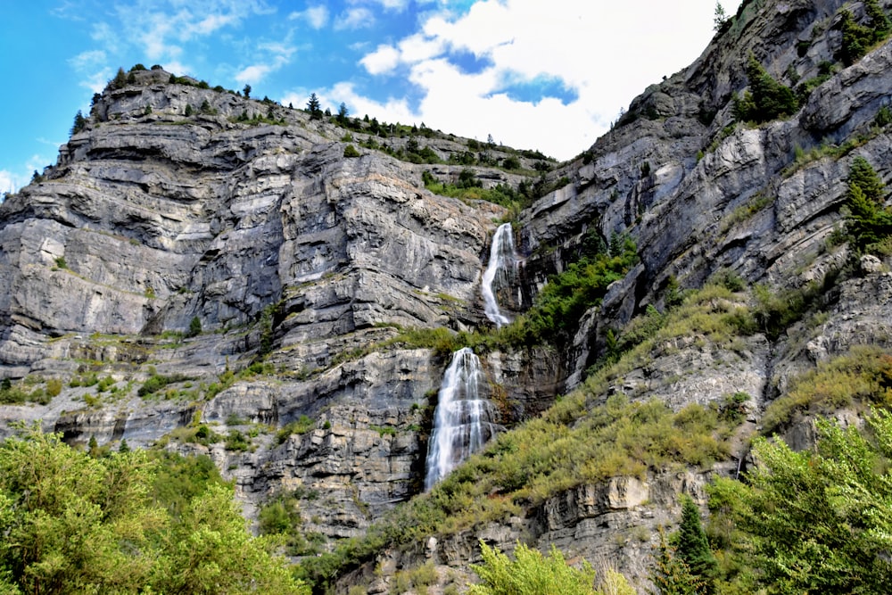 a large waterfall cascading over a lush green hillside