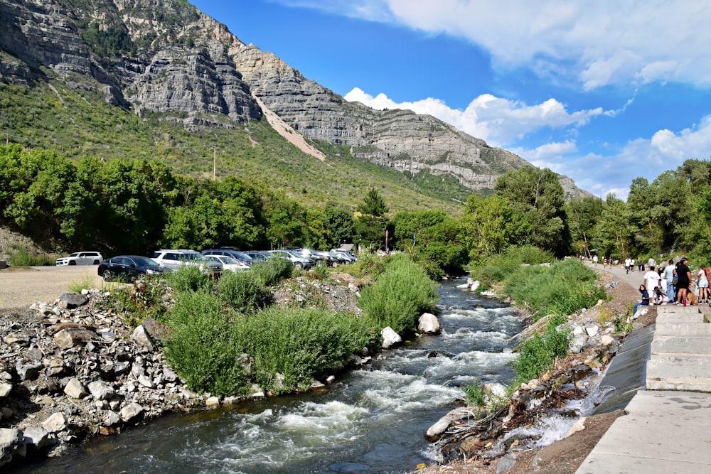 a group of people walking along side of a river