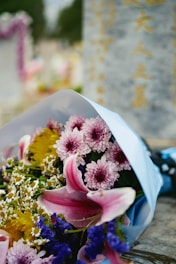 a bouquet of flowers is wrapped in a blue paper