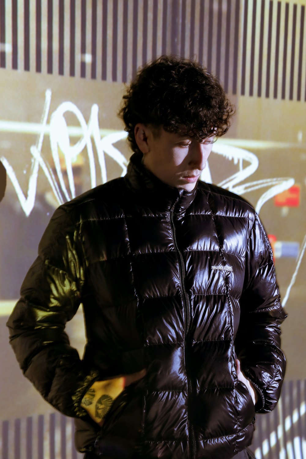 a man standing in front of a graffiti covered wall