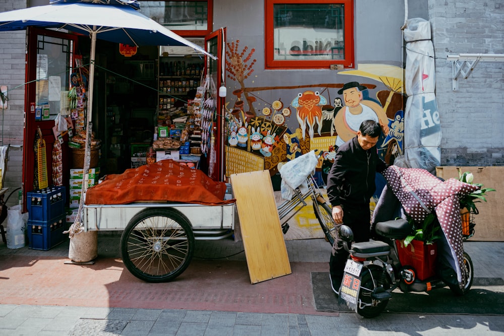 a man on a scooter with a cart full of items