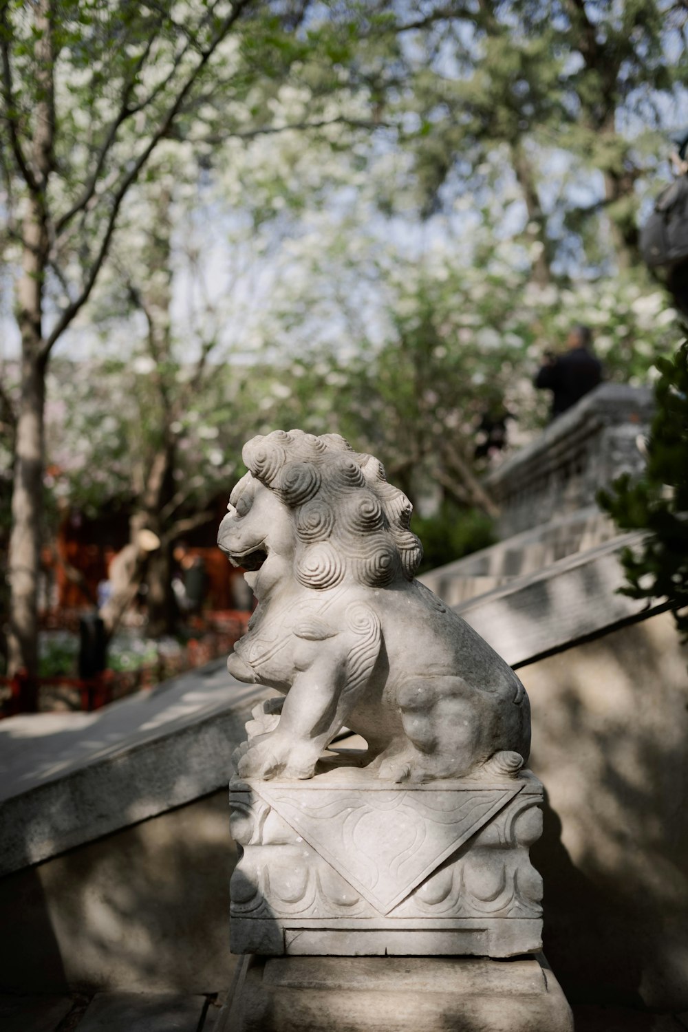 a statue of a lion sitting on top of a white pedestal