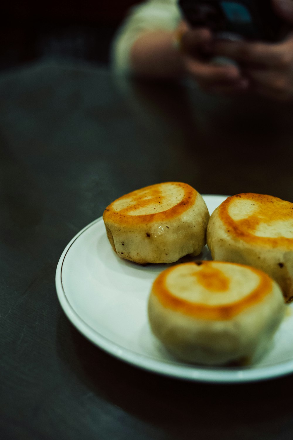 a plate of food on a table with a person taking a picture