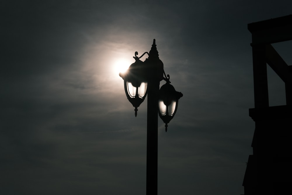 a street light with the sun in the background