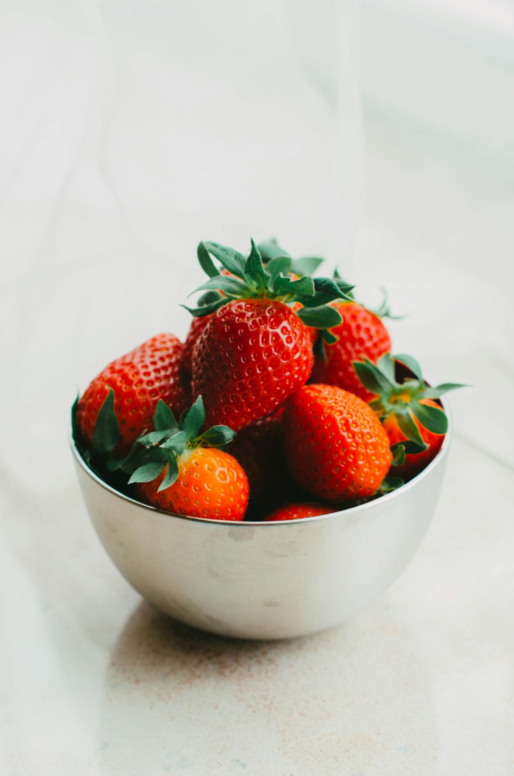 a bowl of strawberries sitting on a table