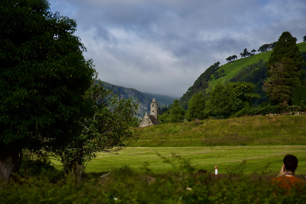 a person sitting in a field with a mountain in the background