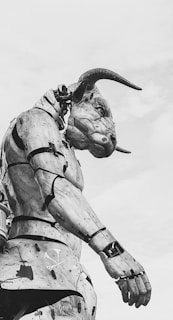 a black and white photo of a statue of a demon