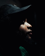 a man wearing a hat in the dark