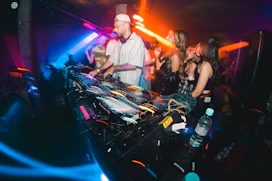 a group of people standing around a dj booth