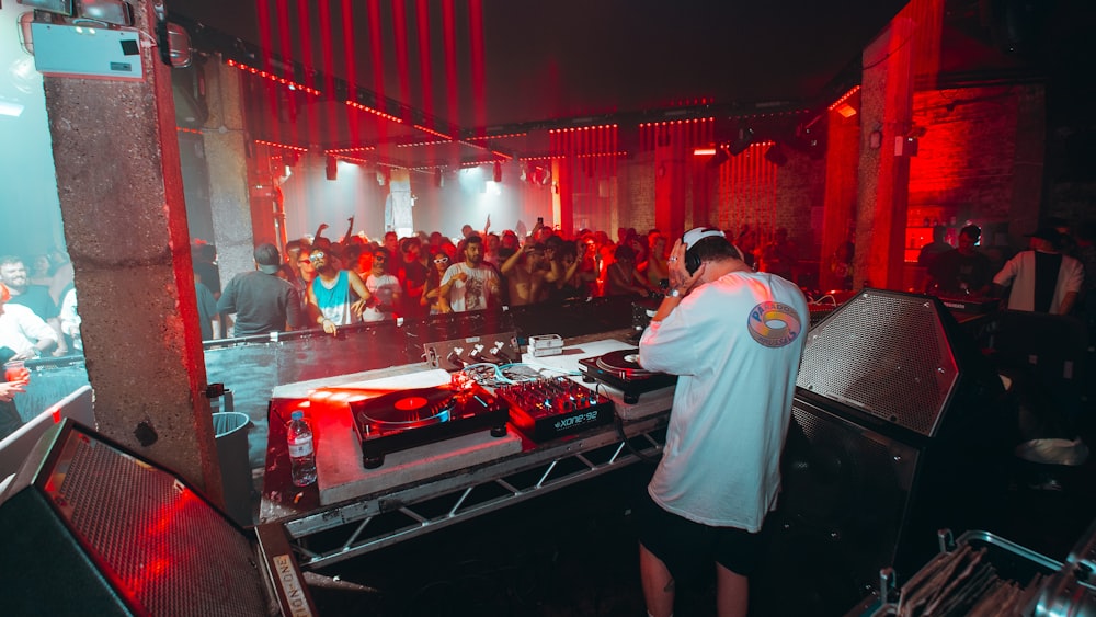 Un DJ che mixa a una festa con una folla di persone