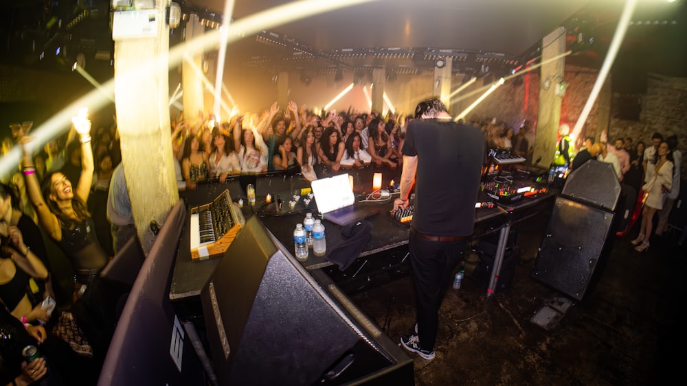 a dj mixing in front of a crowd of people