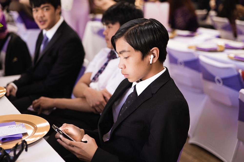 a man in a suit looking at his cell phone