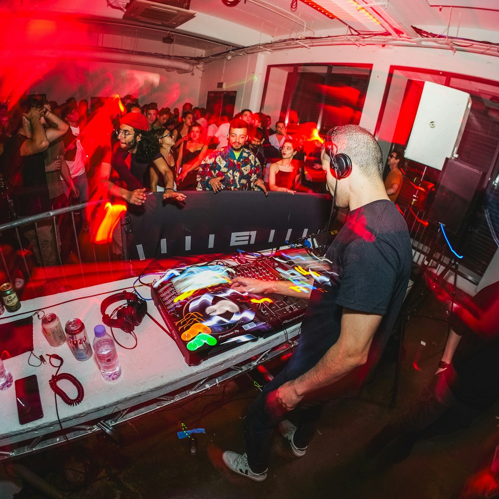 Un DJ che mixa davanti a una folla di persone