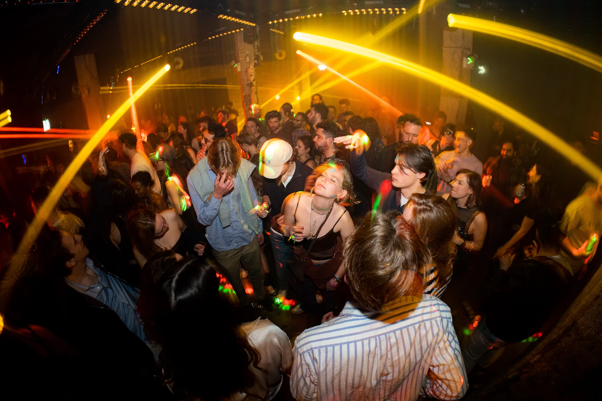 A stylish group of young adult friends dancing and celebrating together