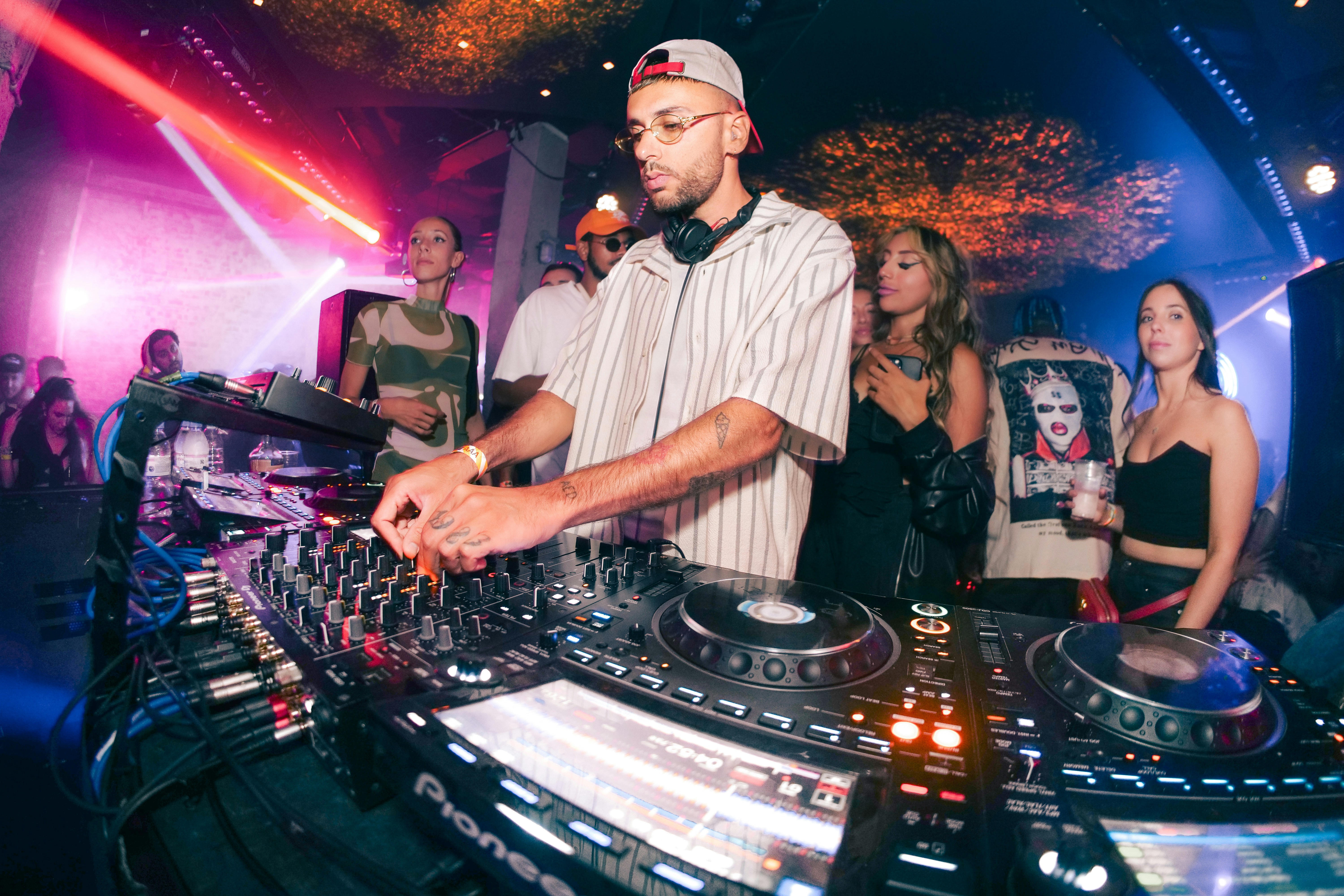 a dj mixing music in front of a crowd of people